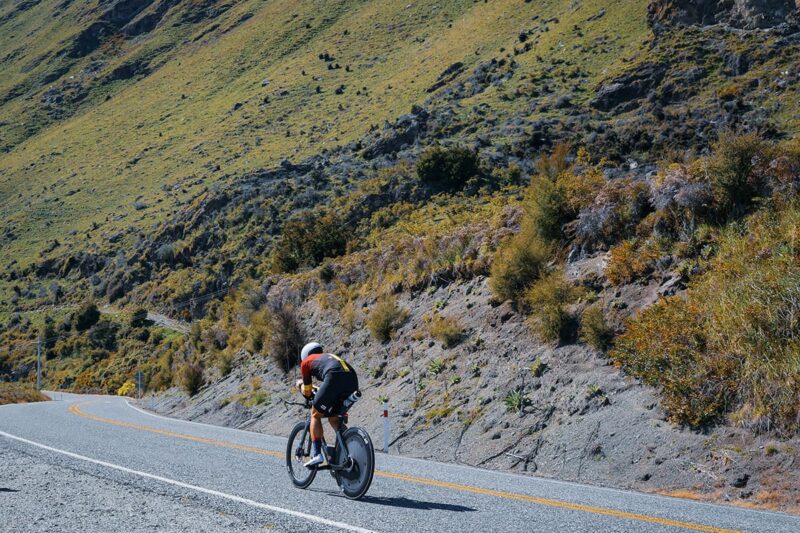 athlete biking with a mountain on the background